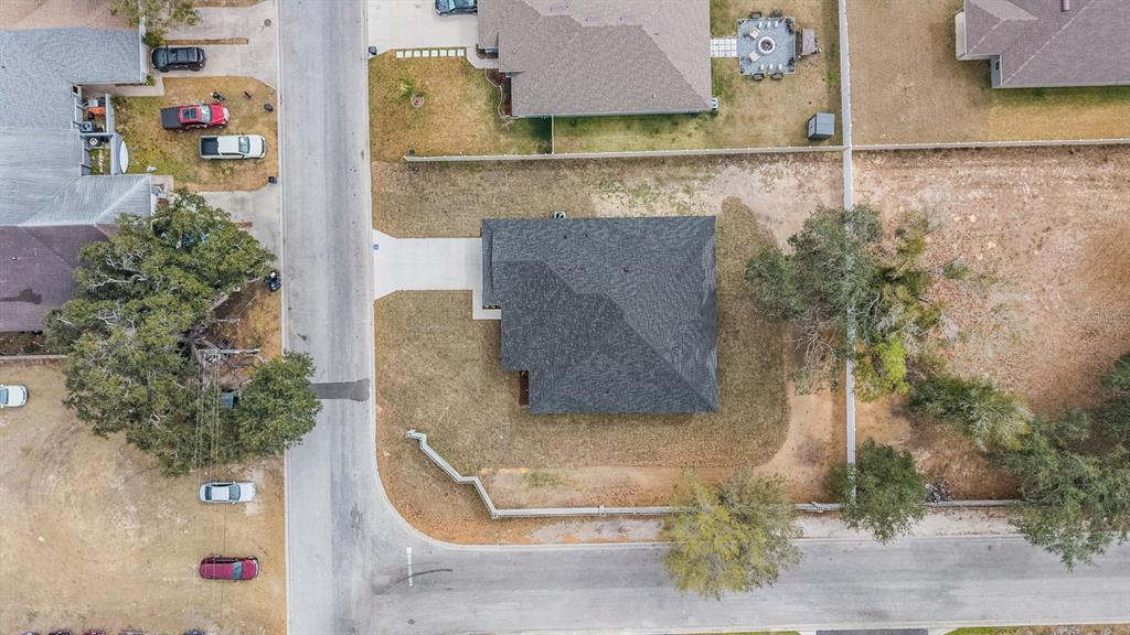 An aerial view shows a residential house with a dark roof on a corner lot — 38086 COUNTRYSIDE PLACE, DADE CITY, FL