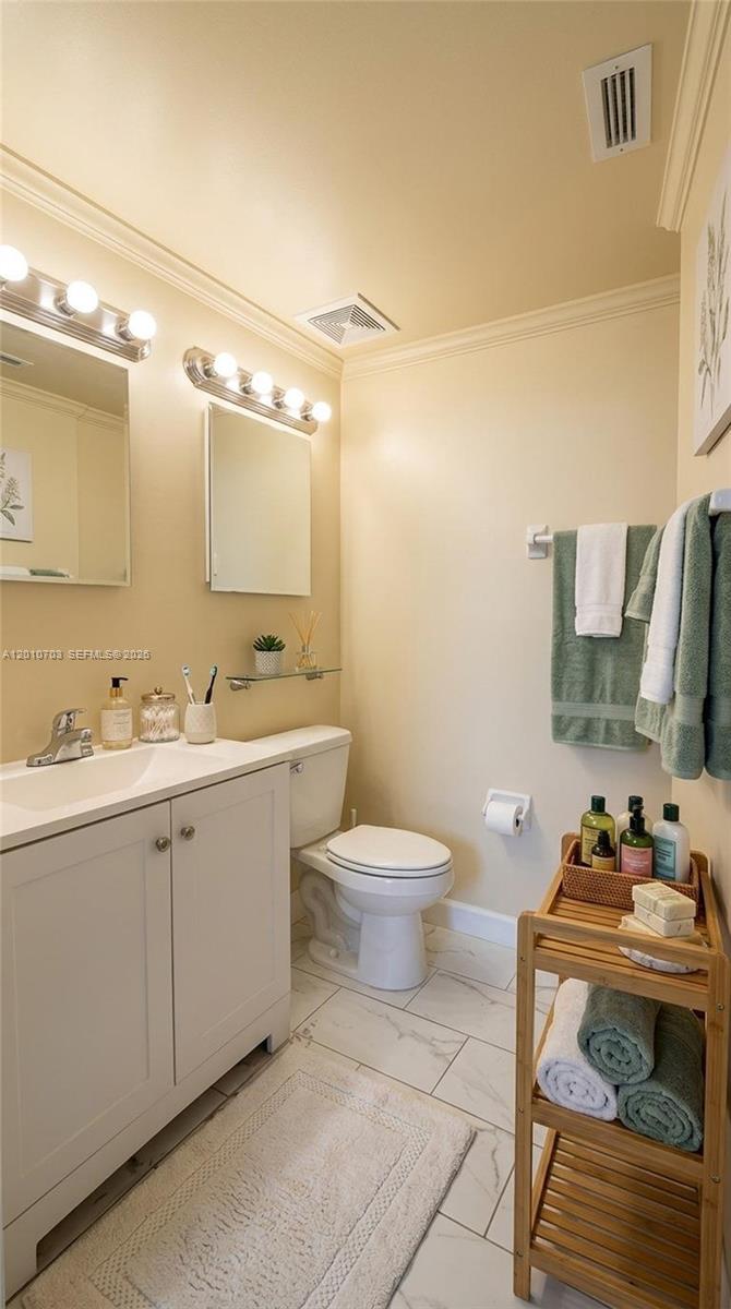 A bathroom features a white vanity, a toilet, a glass shelf, and a bamboo shelving unit — 666 W 81st St # 316, Hialeah FL 33014, HIALEAH, FL