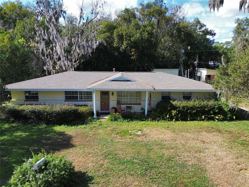 A single-story house with a light-colored exterior, a gabled porch, and a large front yard — 1324 SE 33RD TERRACE, OCALA, FL
