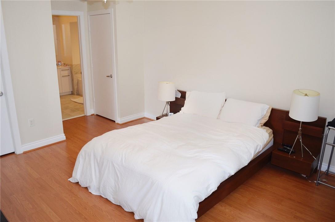 A bedroom features a platform bed with a wooden headboard, two lamps, and hardwood floors — 1060 Brickell Avenue # 1617, Miami FL 33131, MIAMI, FL