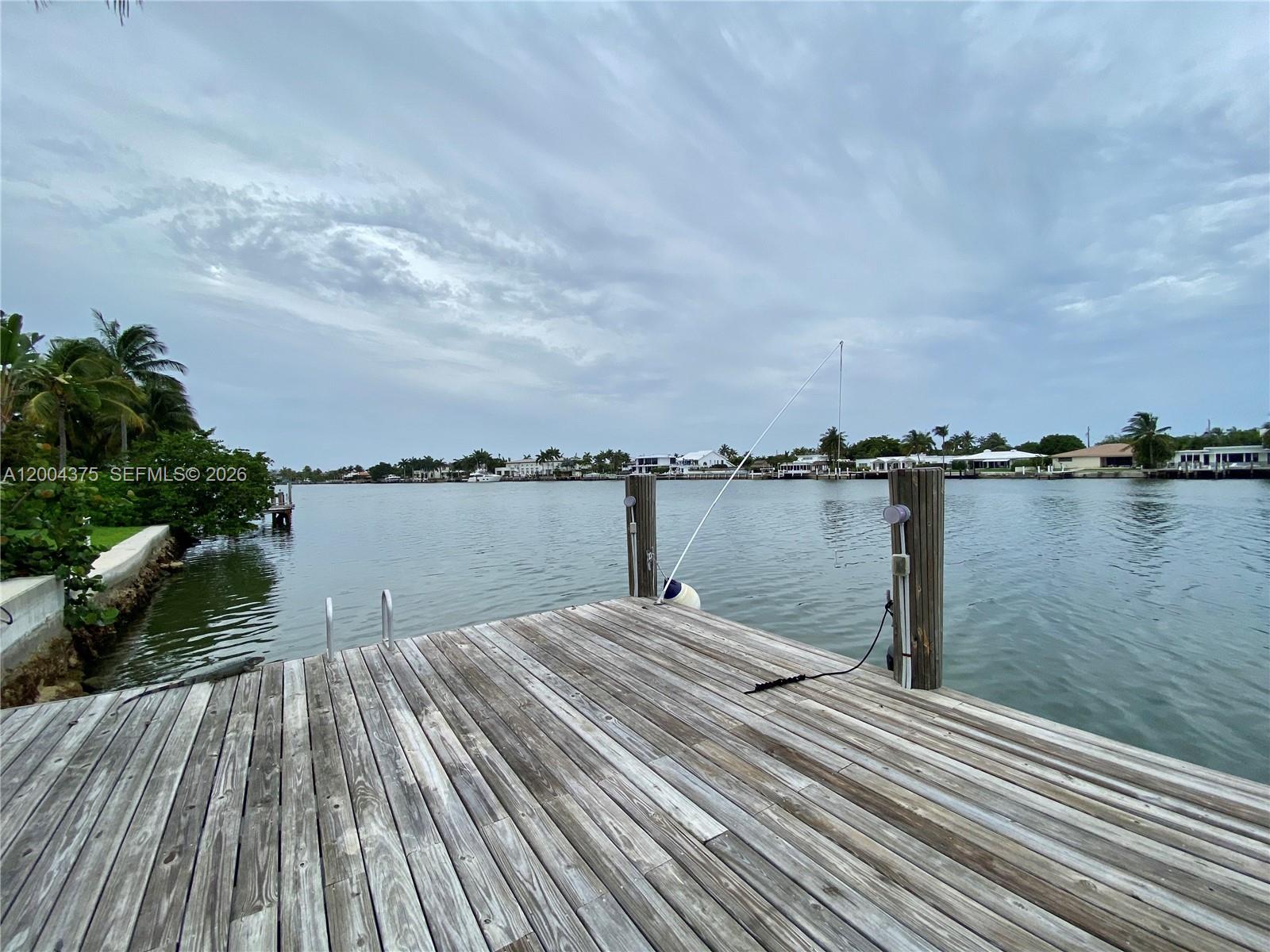 A wooden dock extends into a calm waterway under a cloudy sky — 265 N Shore Dr, Miami Beach FL 33141, MIAMI BEACH, FL