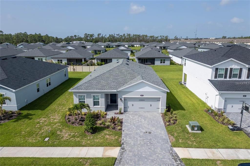 An aerial view shows a single-story suburban house with a gray roof and paved driveway — 16873 CASTORO DRIVE, PORT CHARLOTTE, FL