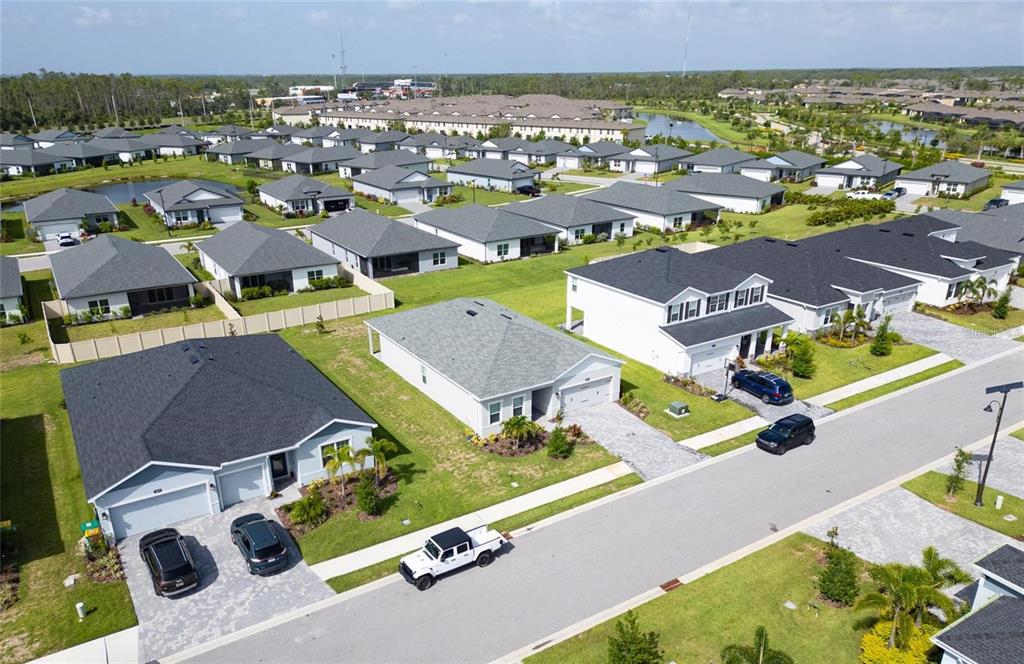 An aerial view shows a suburban neighborhood with single-family homes, paved driveways, and green lawns — 16873 CASTORO DRIVE, PORT CHARLOTTE, FL