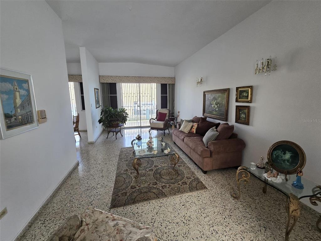 A living room features terrazzo flooring, a brown sofa, and a glass-topped coffee table — 68 SOCORRO STREET, QUEBRADILLAS, PR