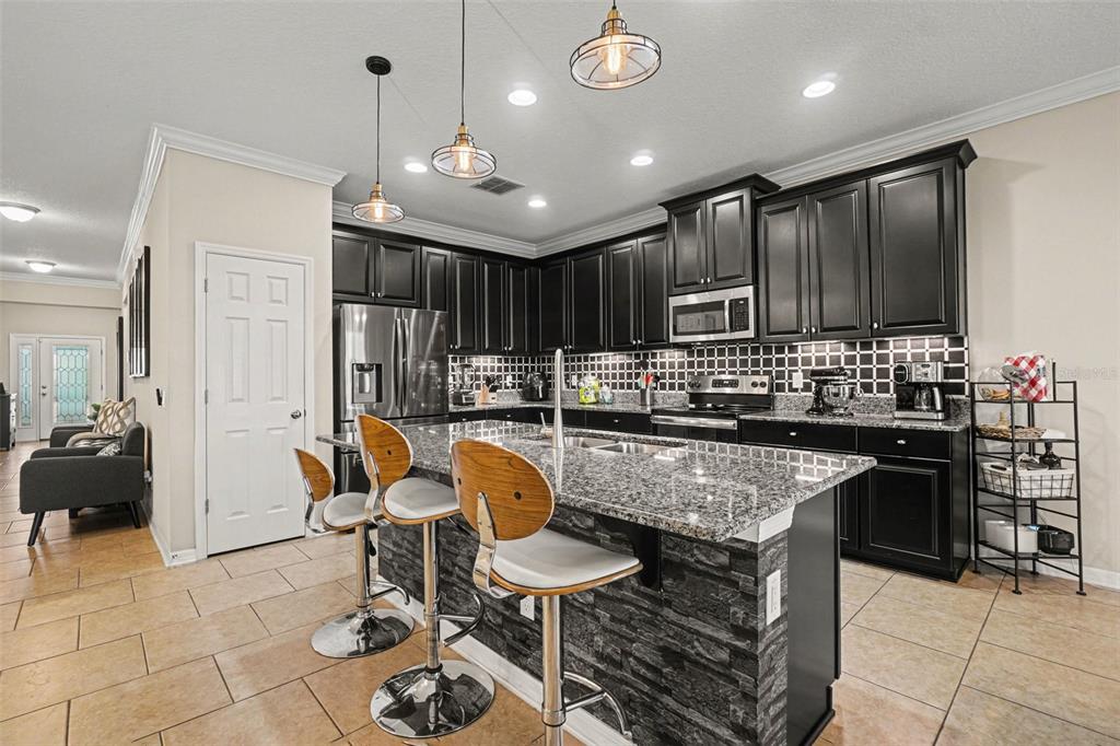 An entryway with tile flooring, a large black mirror, a front door, and a bathroom — 11428 CARLTON FIELDS DRIVE, RIVERVIEW, FL