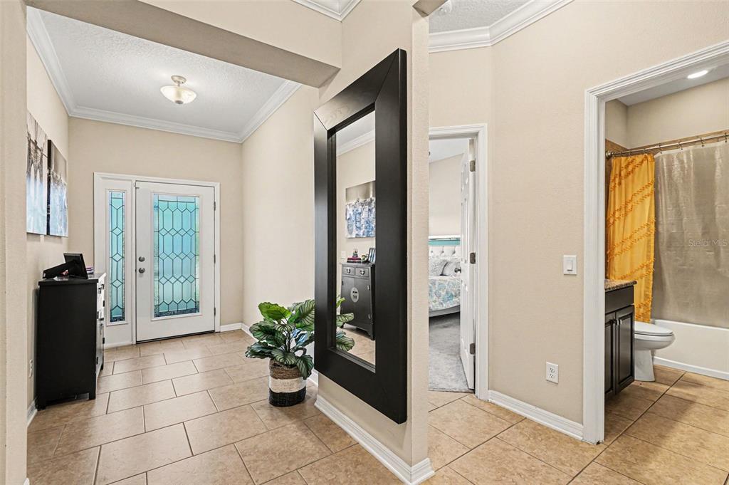 A kitchen features dark cabinets, a granite-topped island with bar stools, and tiled flooring — 11428 CARLTON FIELDS DRIVE, RIVERVIEW, FL