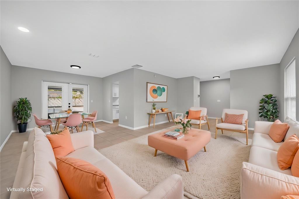 A living room with light gray walls, tile flooring, and light-colored furniture with peach accents — 1803 BALSAWOOD COURT, ORLANDO, FL
