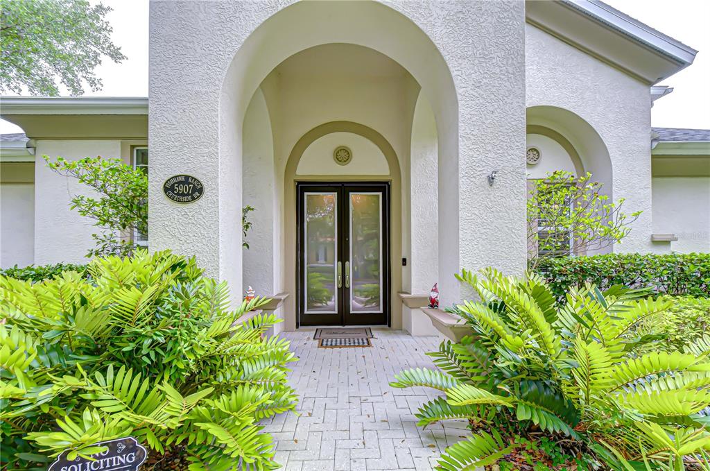 The front exterior of a house features a paved walkway leading to a double-door entrance — 5907 CHURCHSIDE DRIVE, LITHIA, FL