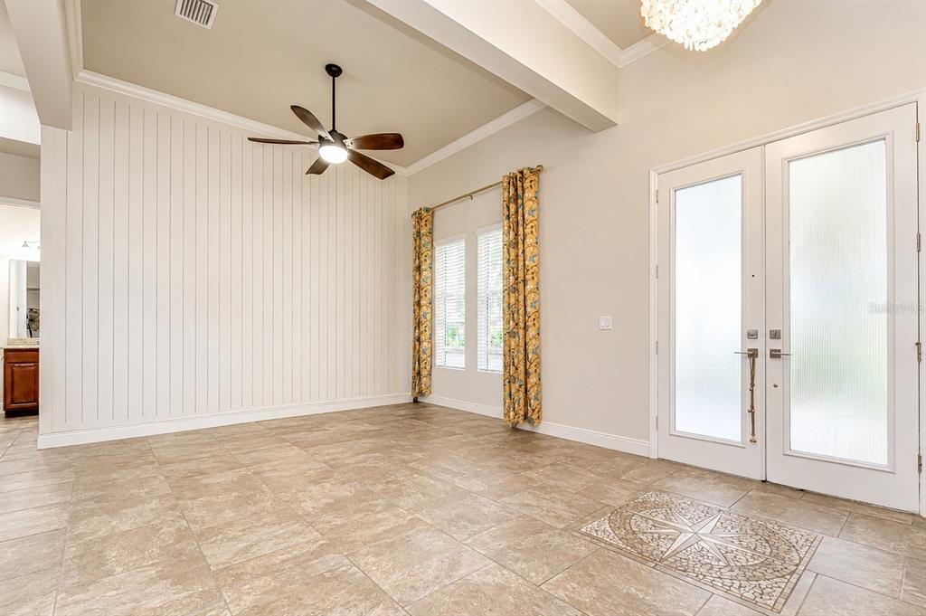 An entryway with tile flooring, a ceiling fan, vertical wall paneling, and double glass doors — 5907 CHURCHSIDE DRIVE, LITHIA, FL