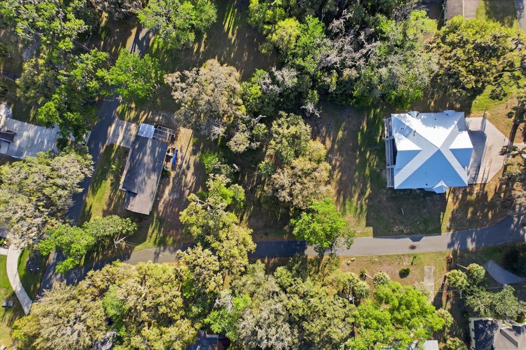 An aerial view shows two houses surrounded by dense trees and a paved driveway — 20 NW MAGNOLIA CIRCLE, CRYSTAL RIVER, FL