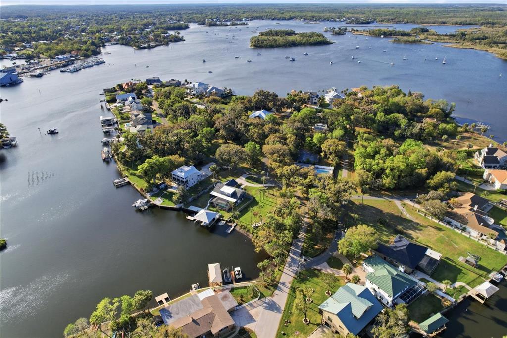 An aerial view shows waterfront homes with private docks along a river and bay — 20 NW MAGNOLIA CIRCLE, CRYSTAL RIVER, FL