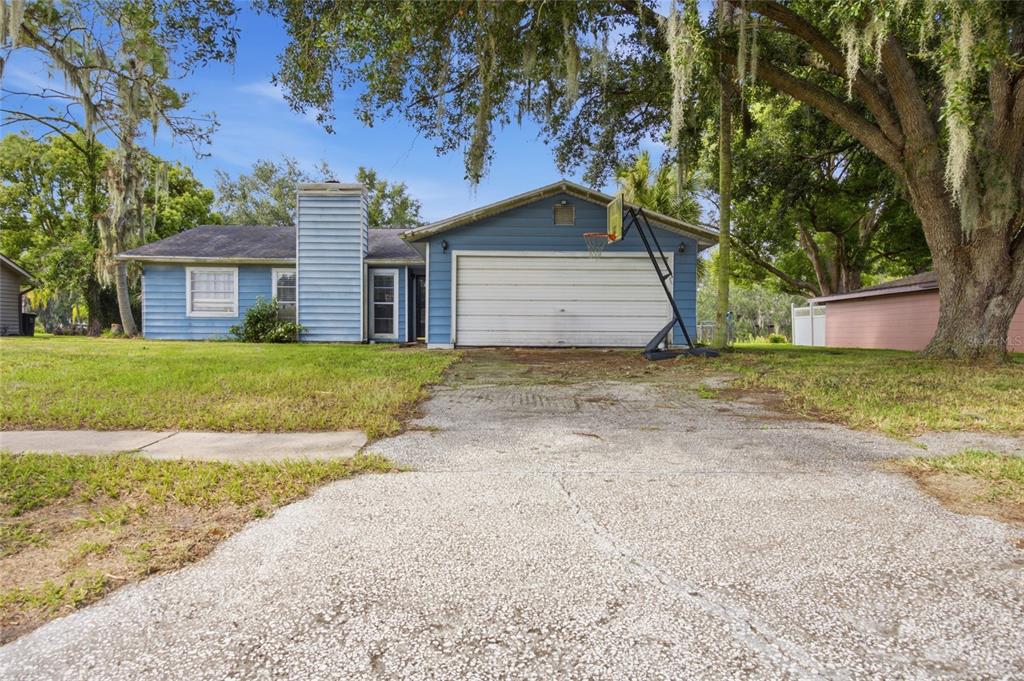 A blue single-story house with a two-car garage and a concrete driveway — 3135 CROSS FOX DRIVE, MULBERRY, FL