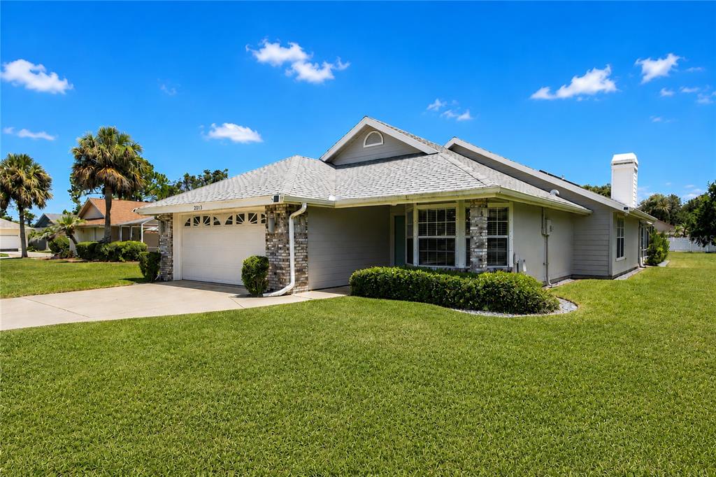 A single-story house with a two-car garage, stone accents, and a large front lawn — 2013 BEAVER CREEK DRIVE, PORT ORANGE, FL