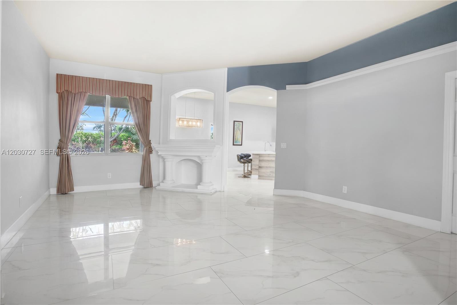A living room features white marble tile floors, a fireplace, and an arched entryway — 19548 S Whitewater Ave, Weston FL 33332, WESTON, FL