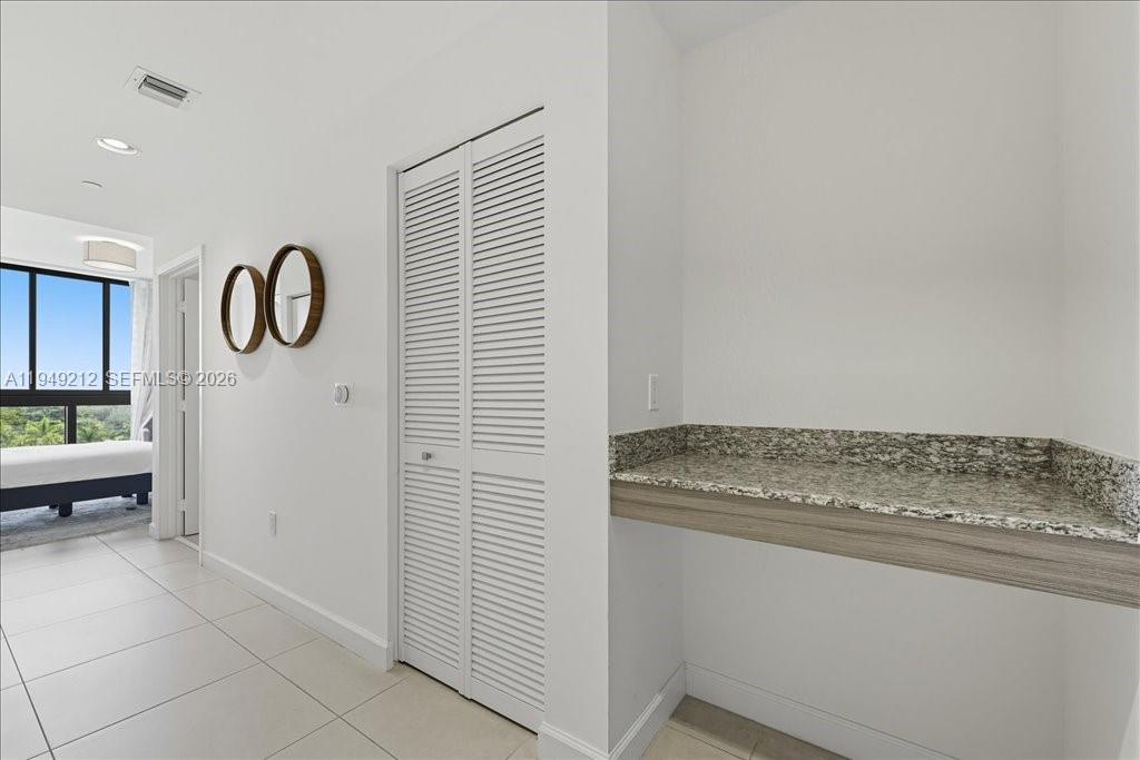 A hallway features white walls, tile flooring, a louvered closet door, and a granite-topped desk — 5350 NW 84th Ave # 505, Doral FL 33166, DORAL, FL