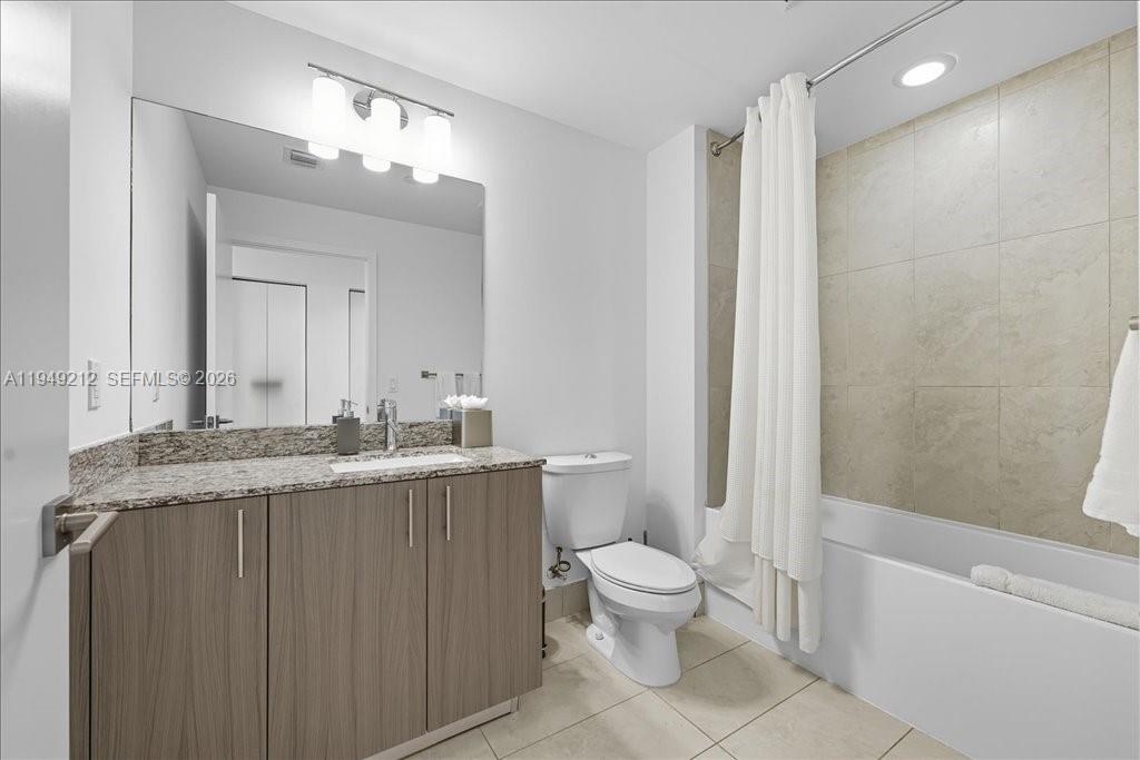 A bathroom features a granite vanity, a large mirror, a toilet, and a tiled tub — 5350 NW 84th Ave # 505, Doral FL 33166, DORAL, FL