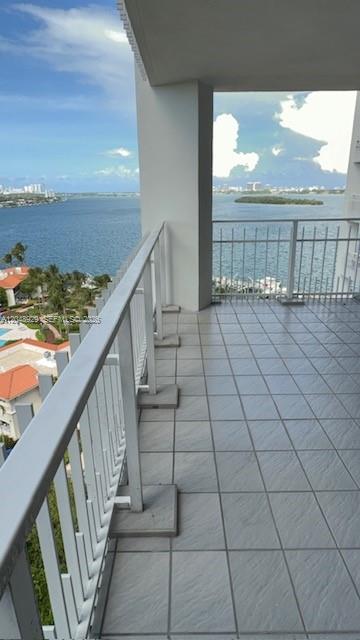 A high-rise balcony features gray tiled flooring, a white metal railing, and panoramic water views — 4000 Towerside Ter # 1403, Miami FL 33138, MIAMI, FL