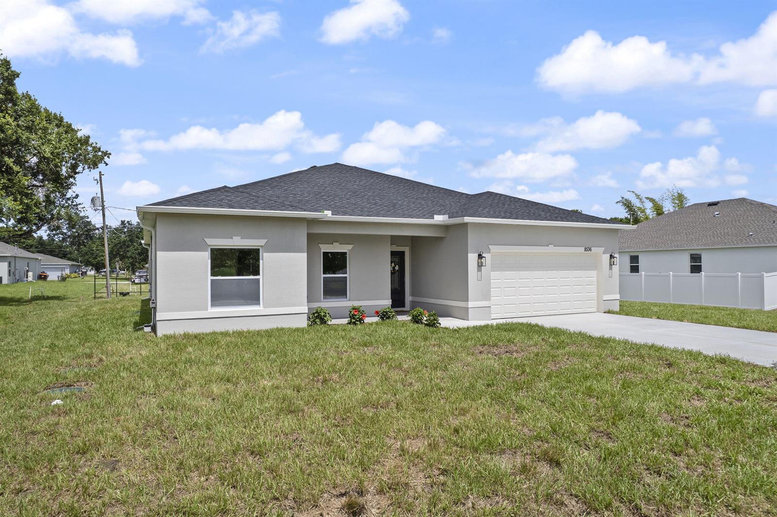 A single-story house with a gray stucco exterior, a dark roof, and a two-car garage — 8536 96th Court, Vero Beach FL 32967, VERO BEACH, FL