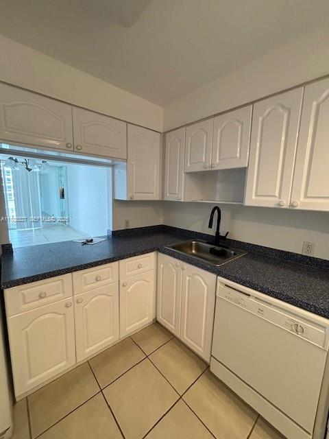 A kitchen features white cabinets, dark blue countertops, a stainless steel sink, and tile flooring — 5701 Collins Ave # 709, Miami Beach FL 33140, MIAMI BEACH, FL