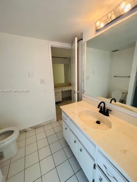 A bathroom features a white vanity with a sink, a large mirror, and tiled flooring — 5701 Collins Ave # 709, Miami Beach FL 33140, MIAMI BEACH, FL