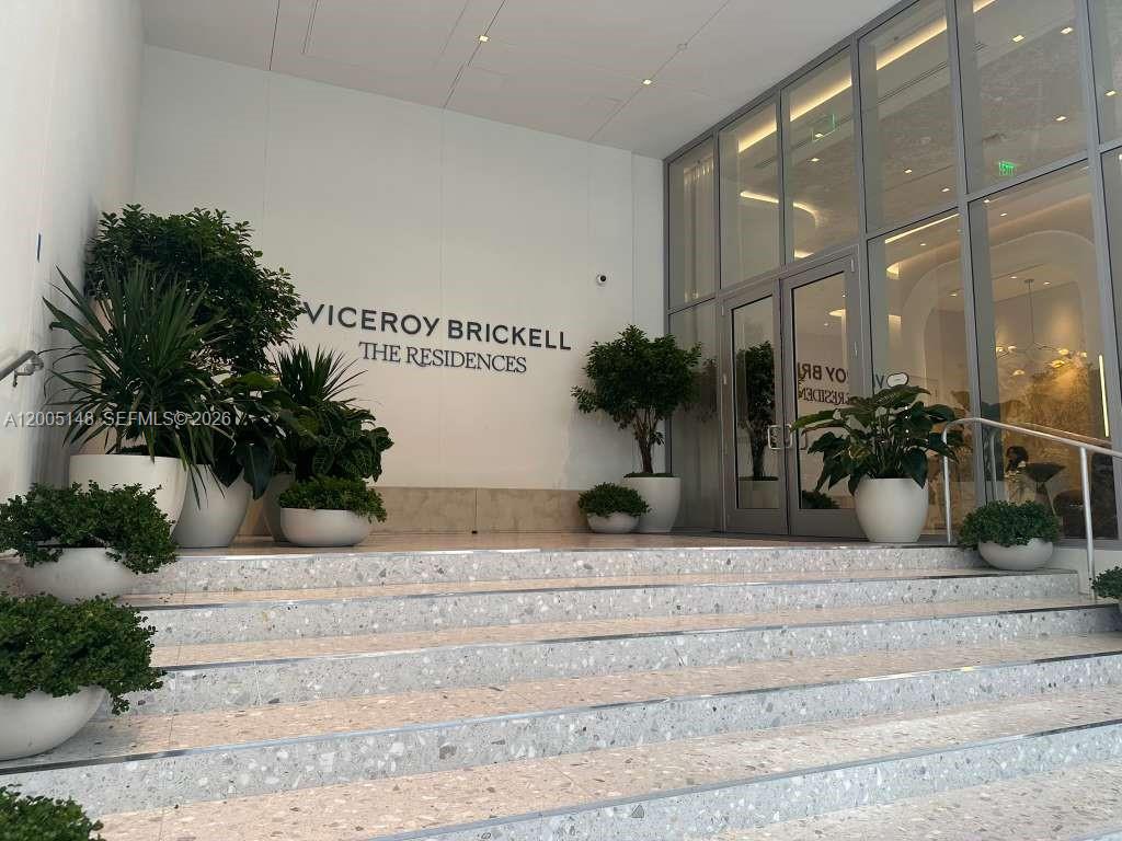 The entrance to a building features a set of stairs leading to glass doors — 77 SE 5th Street # 1815, Miami FL 33131, MIAMI, FL