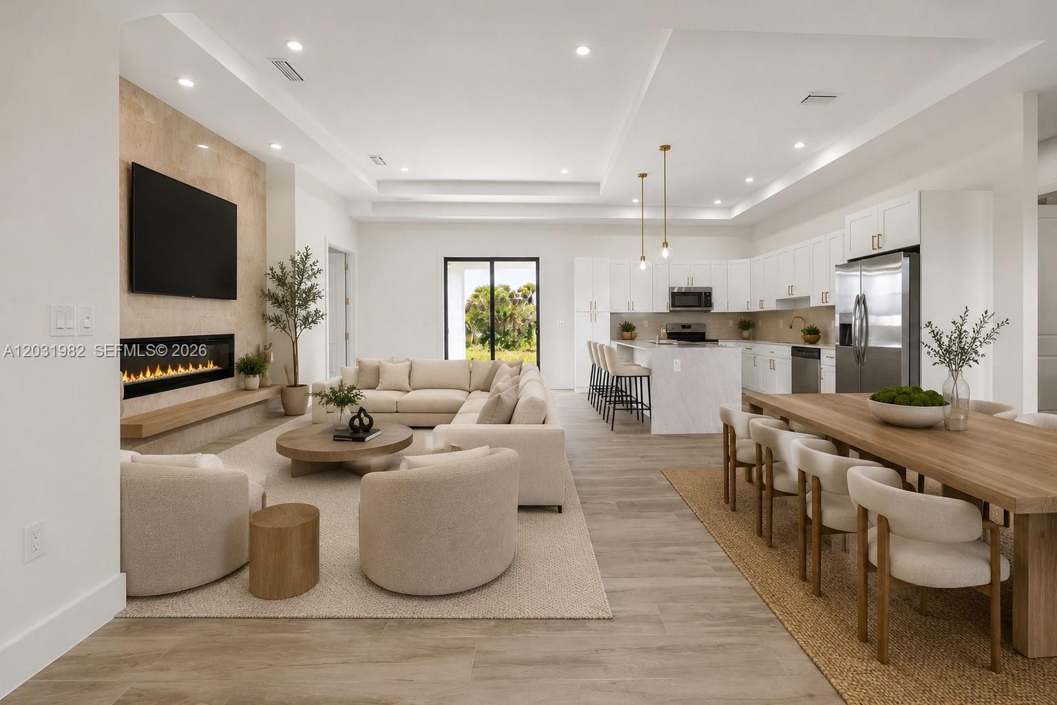 An open-concept living room and kitchen featuring a stone fireplace, sectional sofa, and dining table — 2622 22 Avenue SE, Naples FL 34117, NAPLES, FL