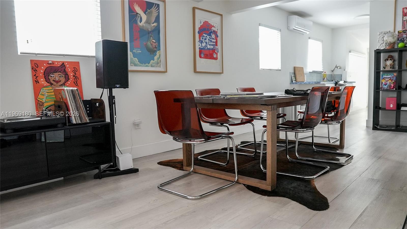 A dining room features a wooden table, translucent red chairs, and a cowhide rug — 3010 NW 1st Ave # 0, Miami FL 33127, MIAMI, FL