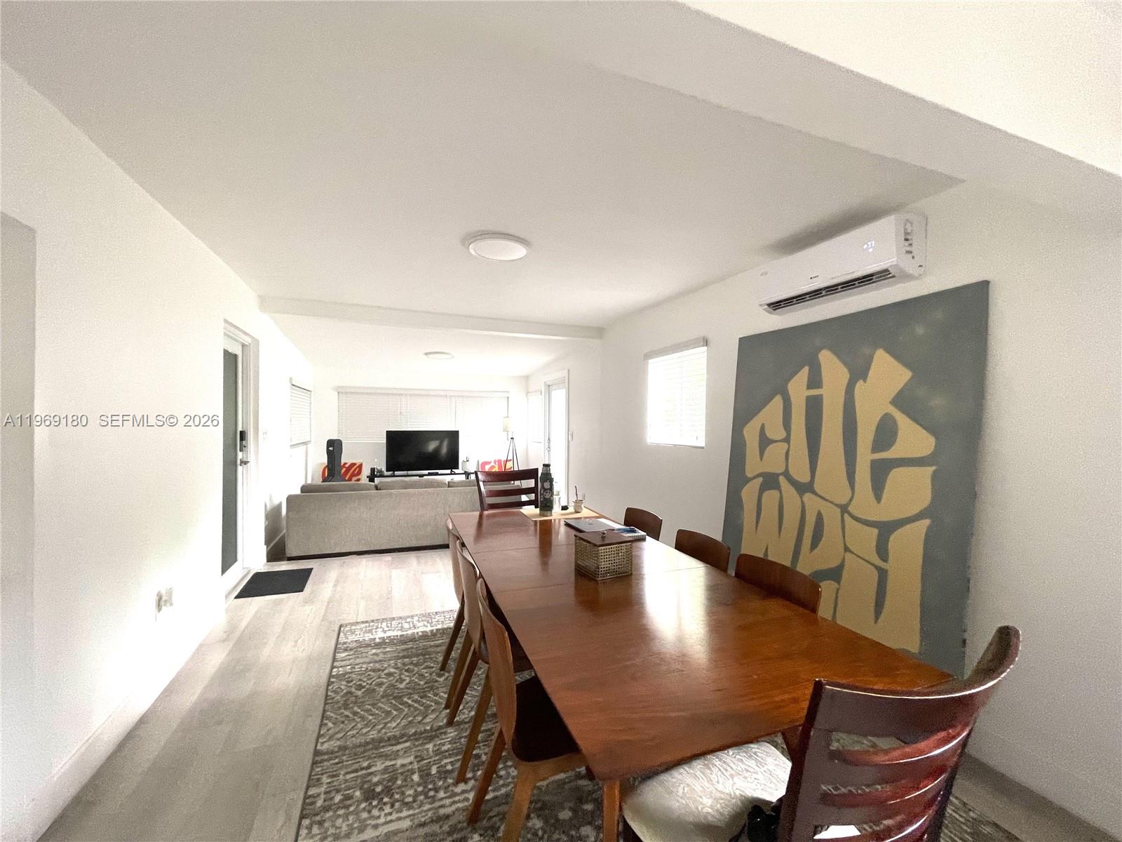 A dining room with a wooden table and chairs sits adjacent to a living area — 3010 NW 1st Ave # 0, Miami FL 33127, MIAMI, FL