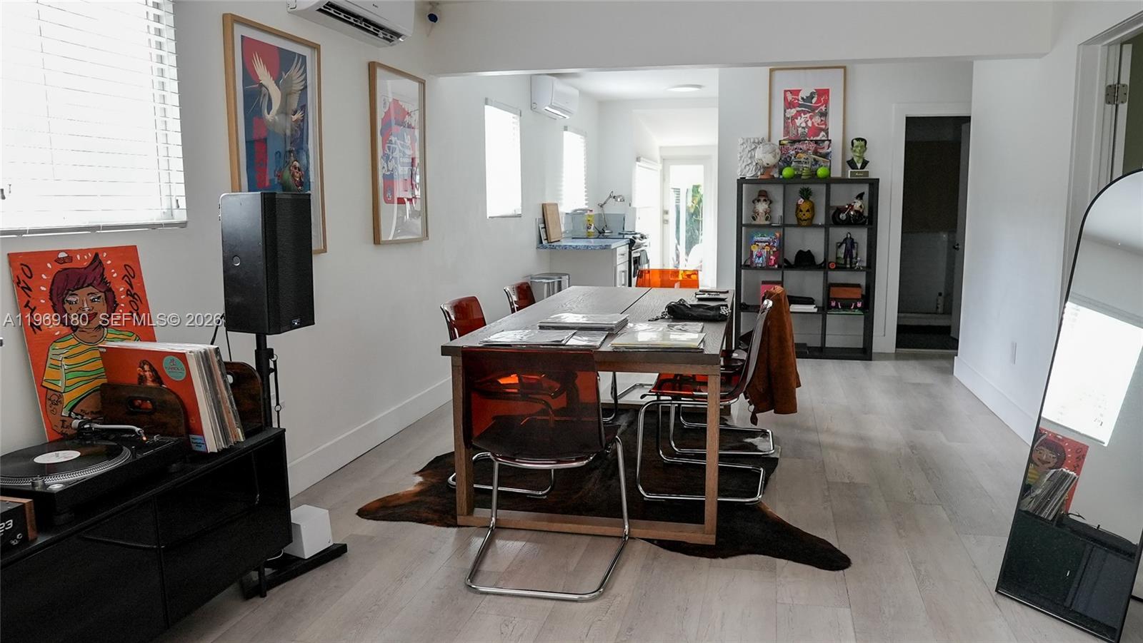 A dining area features a wooden table, transparent chairs, a cowhide rug, and shelving — 3010 NW 1st Ave # 0, Miami FL 33127, MIAMI, FL