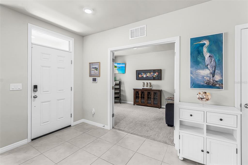 An entryway with tiled floors leads into a carpeted room through double doors — 25008 E LENOX CIRCLE, PUNTA GORDA, FL