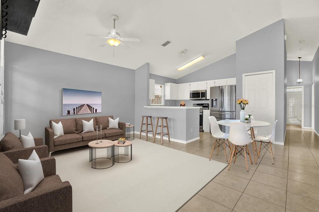 A living room and dining area with tile floors, a brown sofa, and white cabinets — 1618 CITRUS ORCHARD WAY, VALRICO, FL