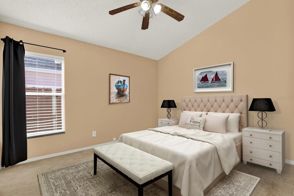 A bedroom features a tufted headboard, two nightstands with lamps, a bench, and wall art — 1618 CITRUS ORCHARD WAY, VALRICO, FL