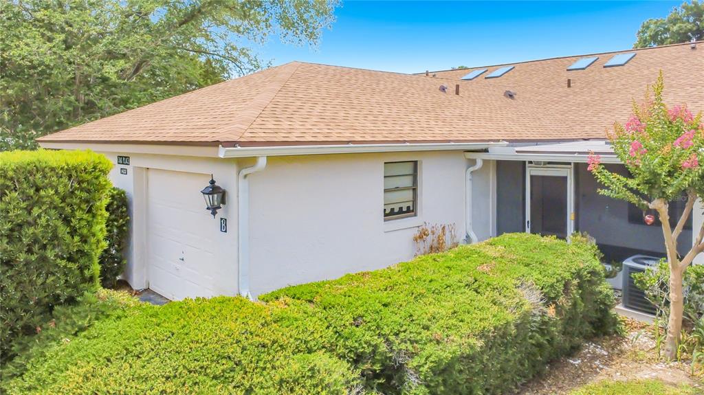 An aerial view of a single-story house with a tan shingled roof and surrounding trees — 1423 OAK PLACE UNIT B, APOPKA, FL