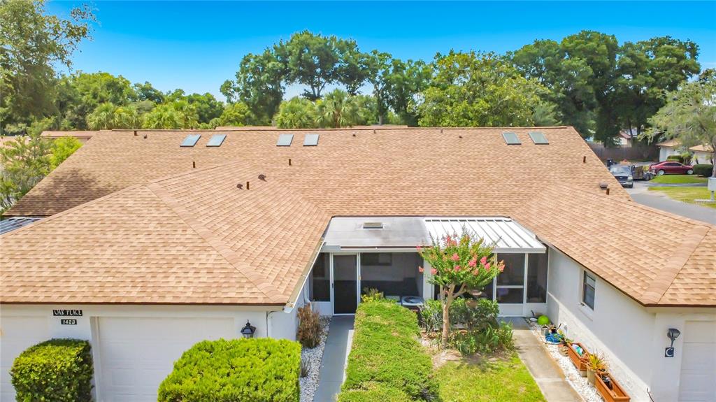 A covered porch features a red front door, a window, and blue carpeted flooring — 1423 OAK PLACE UNIT B, APOPKA, FL