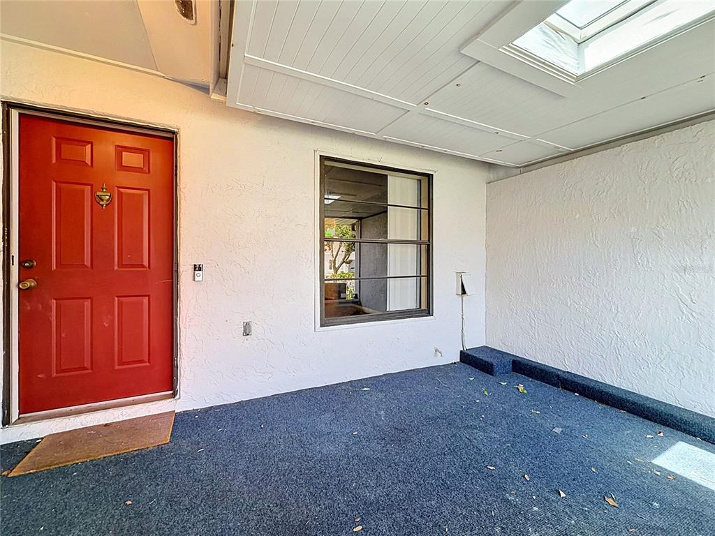 A small room features yellow walls, a checkered floor, a window, and a louvered closet door — 1423 OAK PLACE UNIT B, APOPKA, FL