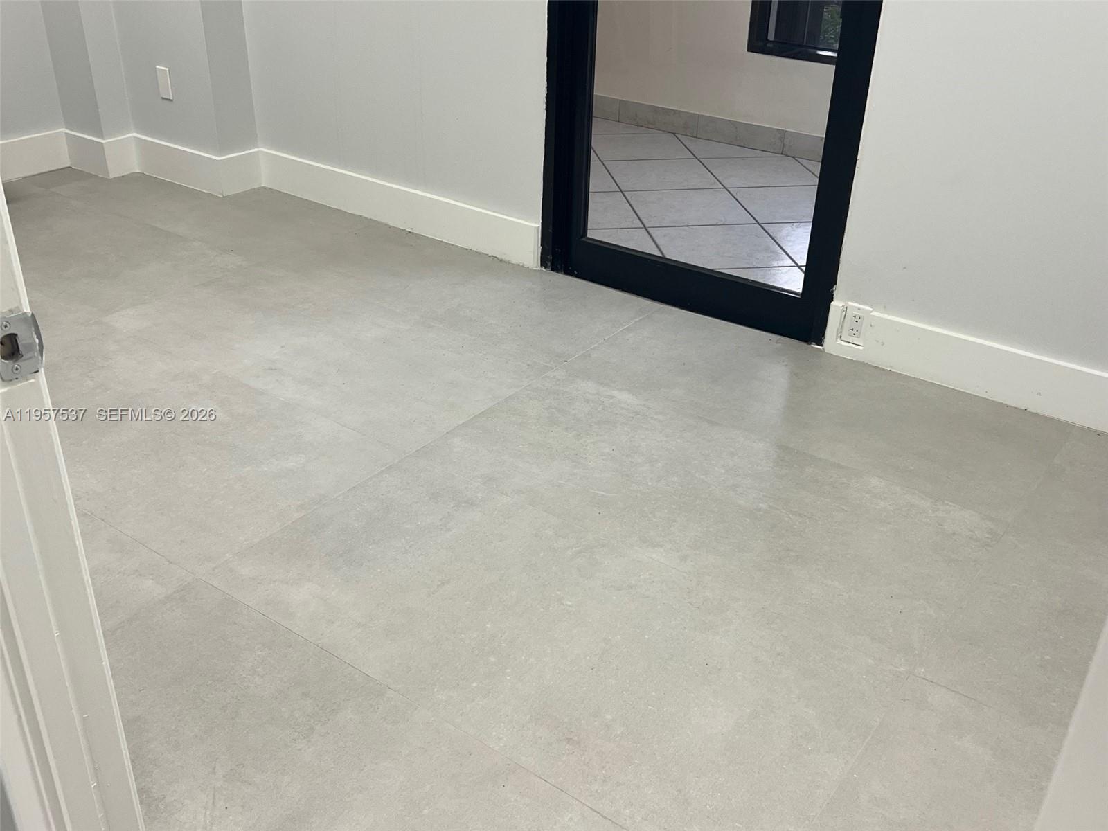 This room features light gray tile flooring, white walls, and a black-framed glass door — 520 Brickell Key Dr # O303, Miami FL 33131, MIAMI, FL