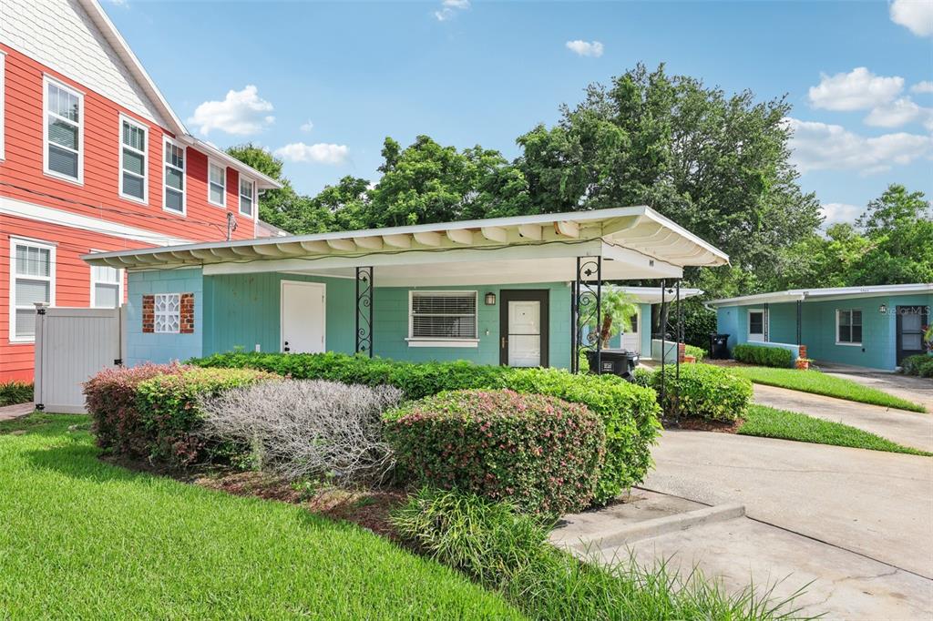A covered concrete patio features teal siding, a white door, and a brown storm door — 1417 E HARDING STREET, ORLANDO, FL