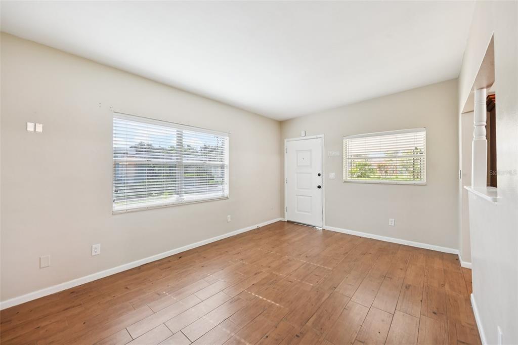 An empty room with wood-look flooring, beige walls, and a window with white blinds — 1417 E HARDING STREET, ORLANDO, FL