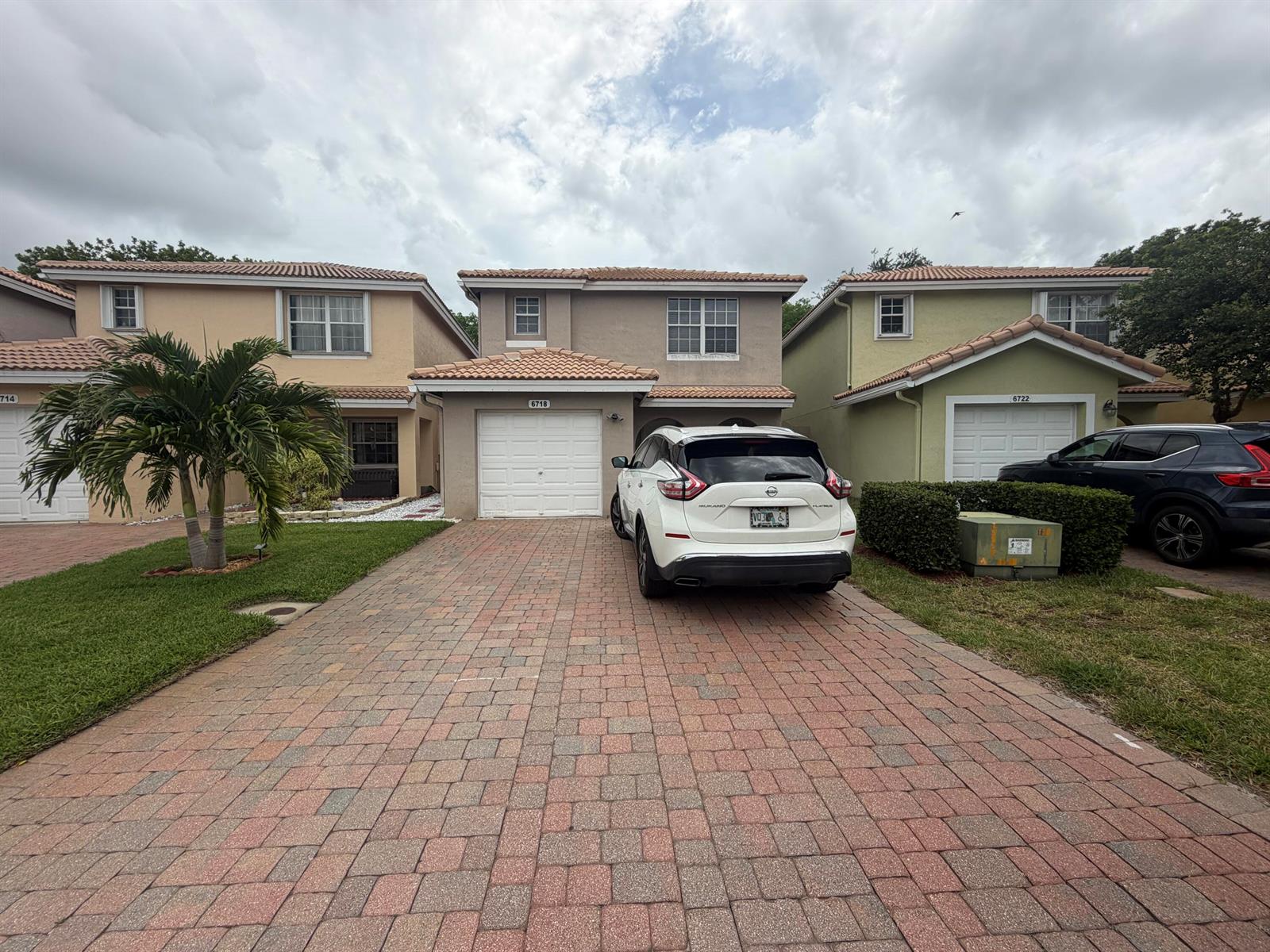 A two-story stucco house with a tiled roof, a paved driveway, and a parked car — 6718 Duval Avenue, West Palm Beach FL 33411, WEST PALM BEACH, FL