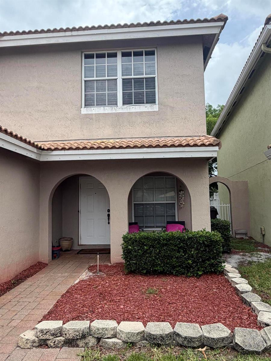 A living room features beige tile flooring, a ceiling fan, and neutral-colored furniture — 6718 Duval Avenue, West Palm Beach FL 33411, WEST PALM BEACH, FL