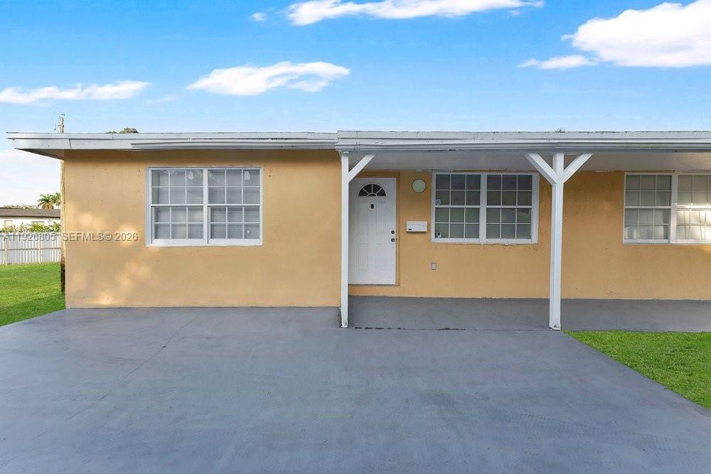 A single-story house with a yellow exterior, a covered porch, and a concrete driveway — 417 SW 3rd St, Hallandale Beach FL 33009, HALLANDALE BEACH, FL
