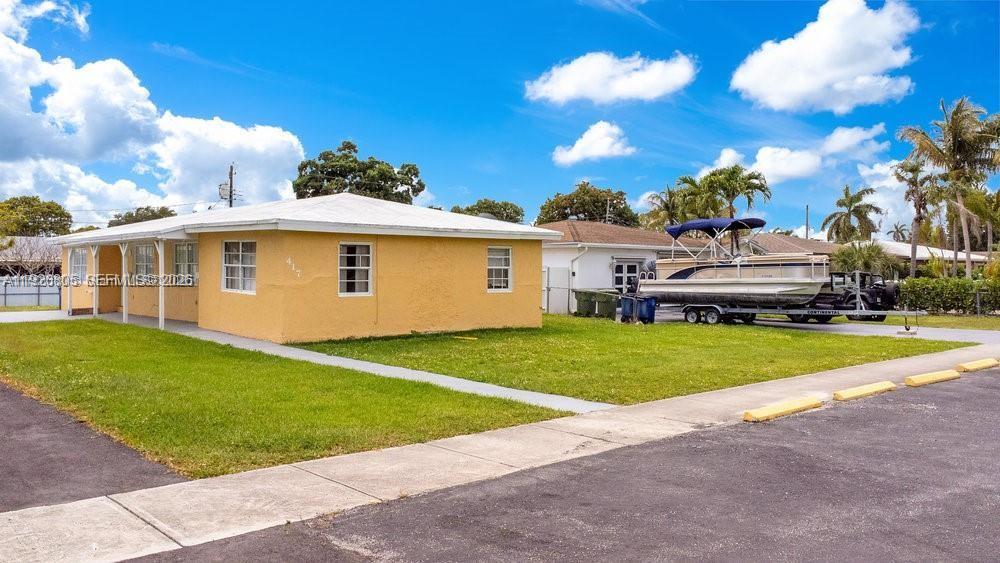 A yellow single-story house with a white roof sits on a grassy lot — 417 SW 3rd St, Hallandale Beach FL 33009, HALLANDALE BEACH, FL