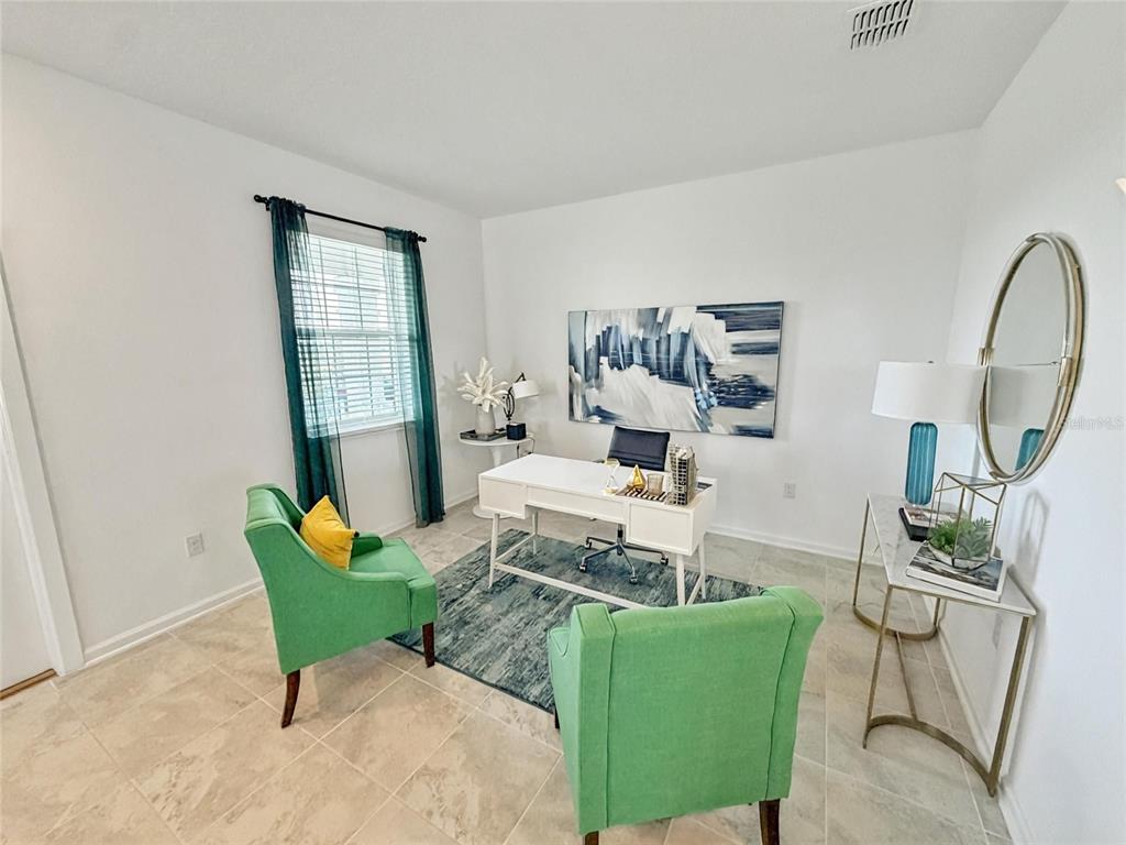 A home office features a white desk, two green armchairs, and a blue area rug — 1692 TOHOQUA BOULEVARD, KISSIMMEE, FL