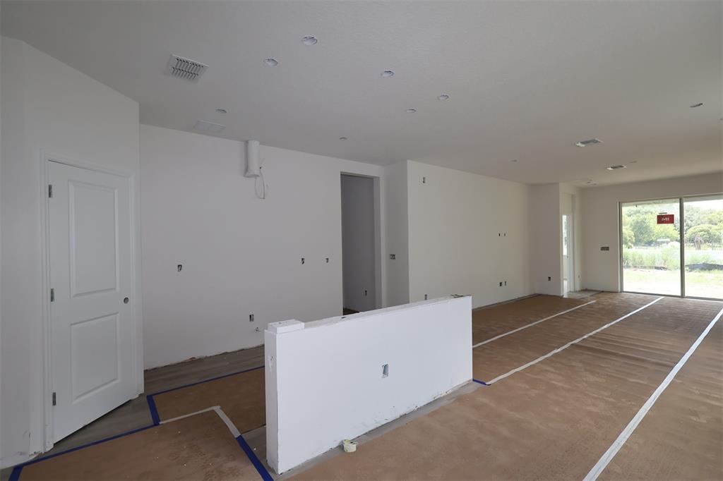 The exterior of a single-story house under construction features a garage and stone veneer siding — 1296 HYDE STREET, ST CLOUD, FL