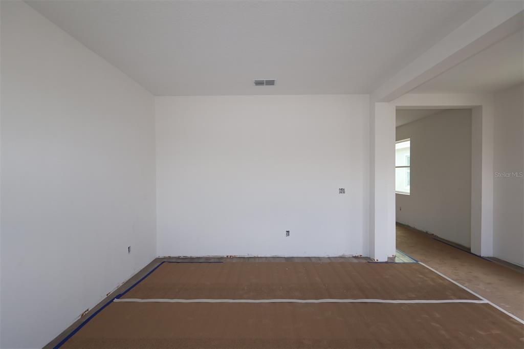 A kitchen with a white island, gray cabinets, stainless steel appliances, and wood-look tile flooring — 1296 HYDE STREET, ST CLOUD, FL