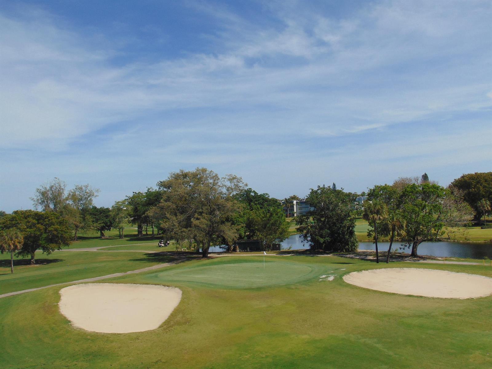 A golf course green is surrounded by sand bunkers, trees, and a small pond — 7640 NW 18th Street # 401, Margate FL 33063, MARGATE, FL