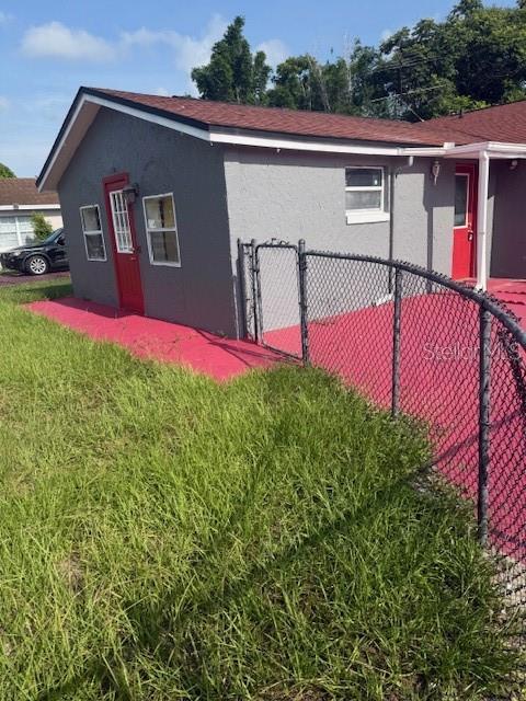 The exterior of a gray house features a red door and a chain-link fence — 388 NOTRE DAME DRIVE, ALTAMONTE SPRINGS, FL