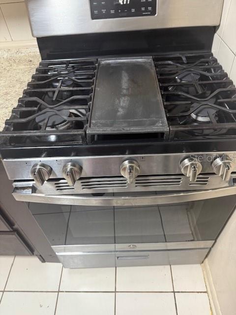 A stainless steel gas range with a center griddle sits on a tiled kitchen floor — 388 NOTRE DAME DRIVE, ALTAMONTE SPRINGS, FL