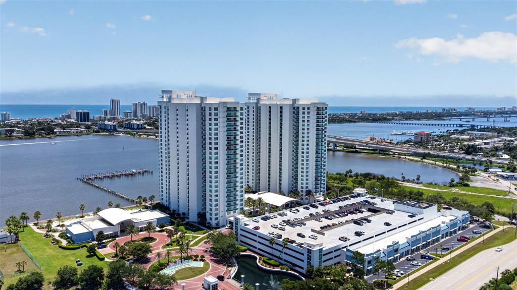 An aerial view shows a high-rise residential complex with a parking garage and waterfront access — 231 RIVERSIDE DRIVE UNIT 1108-1, HOLLY HILL, FL