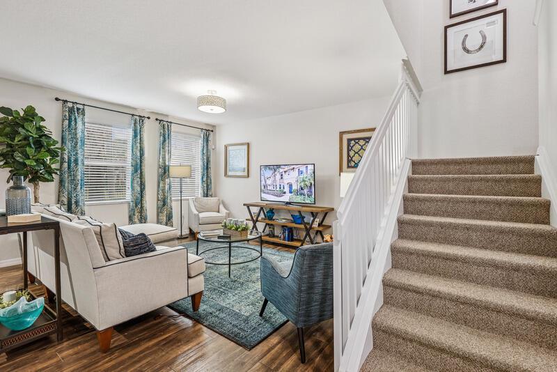 A living room features a carpeted staircase, hardwood floors, and a blue area rug — WEST PALM BEACH, FL